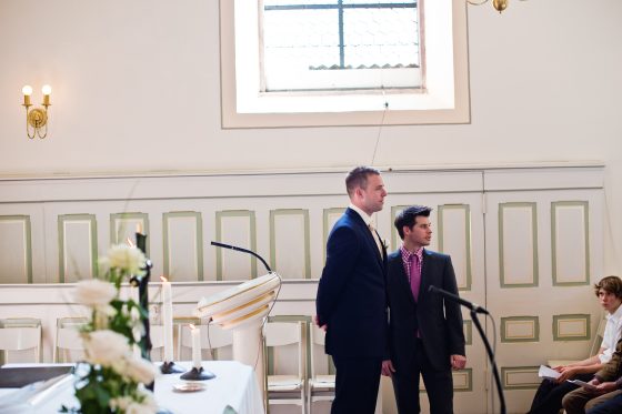 Two men in suits standing in a church.