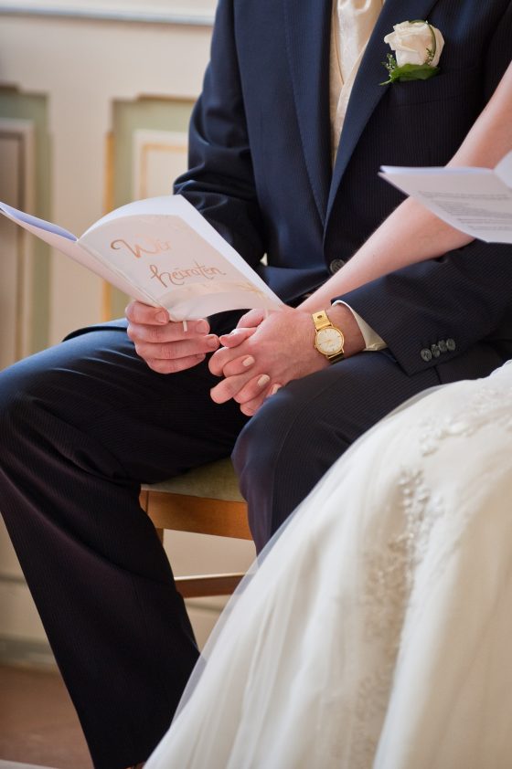 Couple holding wedding brochure at ceremony