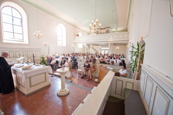Church full of wedding guests and pastor