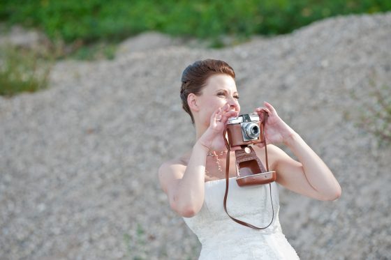 Woman photographed with camera in wedding dress