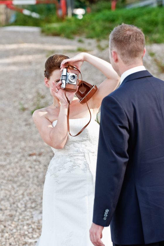 Bride photographs groom with camera