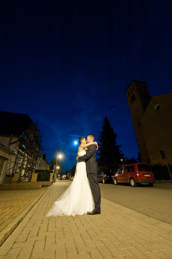 Wedding couple embrace under night lighting