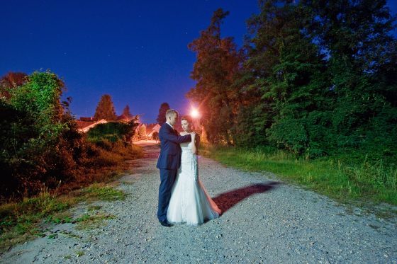 Bride and groom embrace outdoors at night