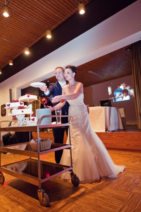 Wedding couple cutting a multi-tiered wedding cake.