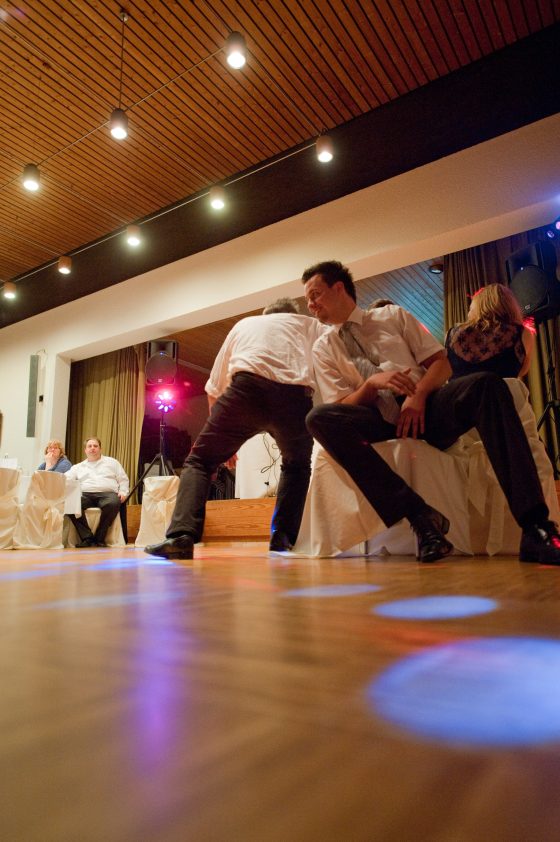 Dancing people at a party with colorful lighting.