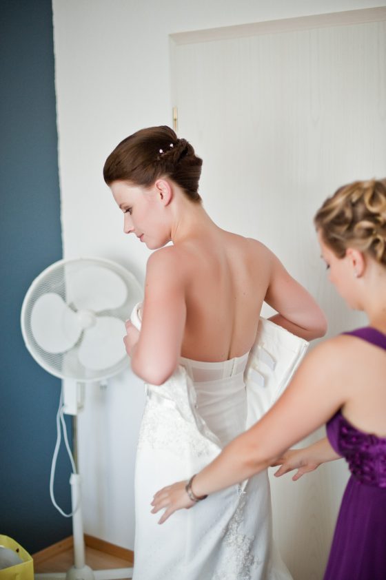 Bride getting dressed in her wedding dress