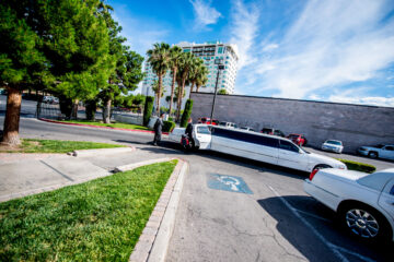 Limousine vor Parkplatz, Personen steigen ein.