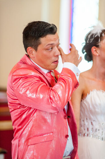 Bräutigam im rosa Anzug während Hochzeit emotional