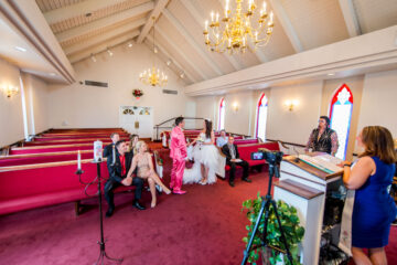 Hochzeitszeremonie in kleiner Kirche mit Gästen.