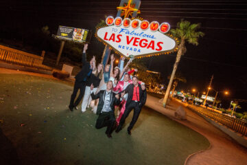 Gruppe feiert beim Las Vegas Schild nachts.