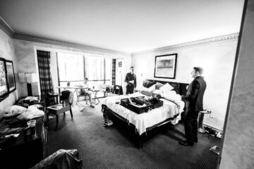 Männer in Anzug in Hotelzimmer, schwarz-weiß Foto.