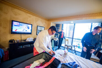 Menschen packen in einem Hotelzimmer Koffer.