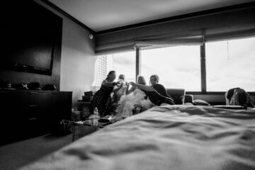 Frauen im Hotelzimmer stoßen gemeinsam an.