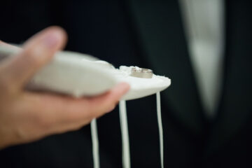Person holding pillow with wedding rings